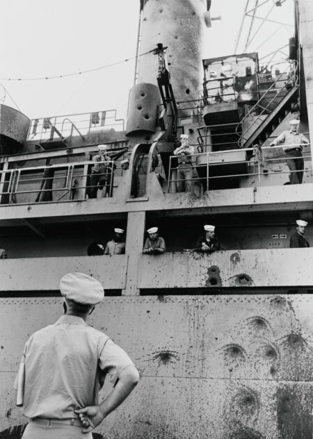 USS Liberty (AGTR-5) 8 Haziran 1967 İsrail saldırısından sonra hasarlı haliyle — torpido ile delinmiş gövde, isabet alan üst yapı ve sancak tarafındaki yara açıkça görünüyor